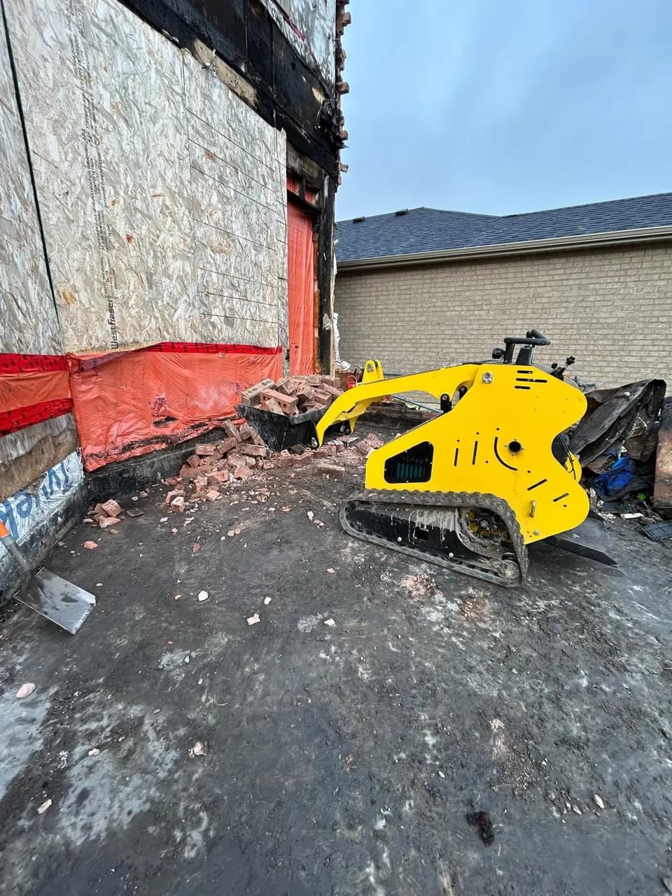 Our mini stand-on track loader carrying bricks on a residential demolition job in the GTA.